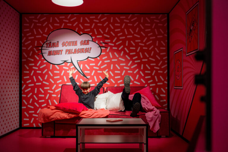 "Father and son enjoying the Paradox Sofa illusion at Paradox Museum Helsinki, experiencing a mind-bending optical illusion.