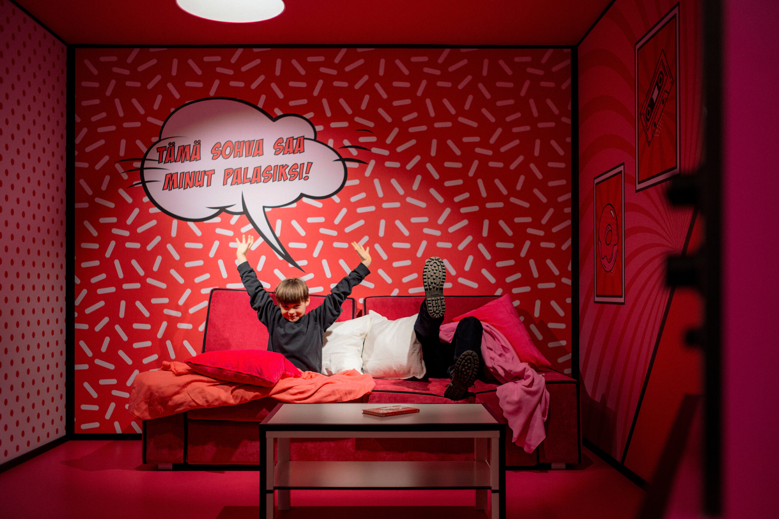 "Father and son enjoying the Paradox Sofa illusion at Paradox Museum Helsinki, experiencing a mind-bending optical illusion.